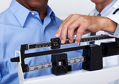 Photo of doctor checking patients weight (arthritis risk factor)