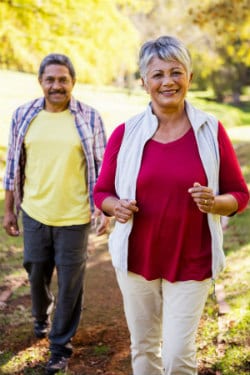 older African american man and woman walking in the park