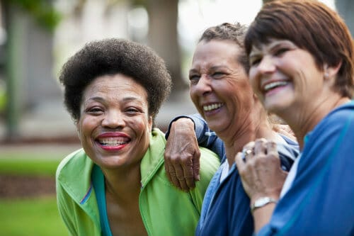 three older women laughing outdoors