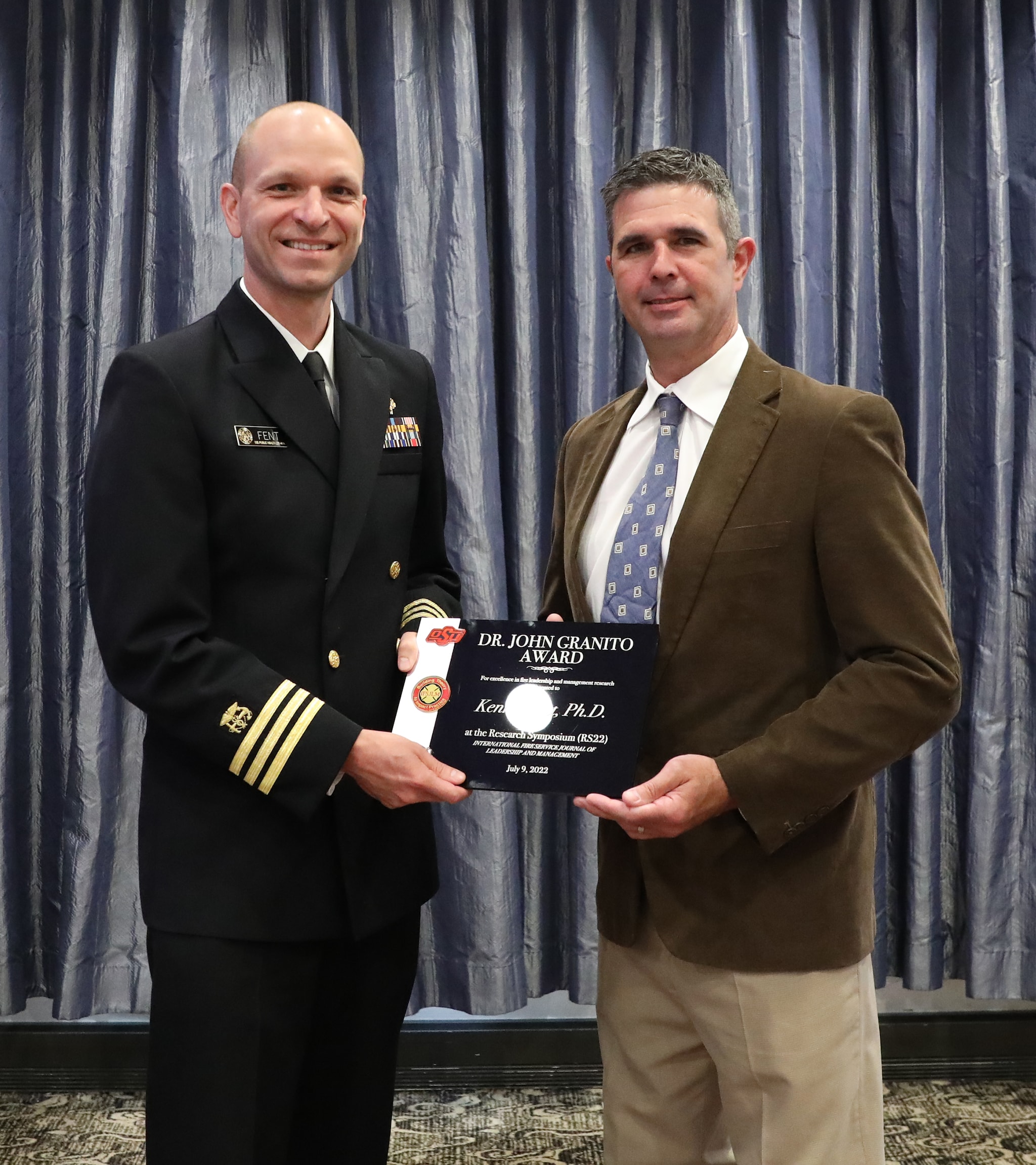 Dr. Kenny Fent (left) receives his award from Dr. Gavin Horn from the Underwriters Laboratories, Fire Safety Research Institute. Photo courtesy of the  International Fire Service Training Association.